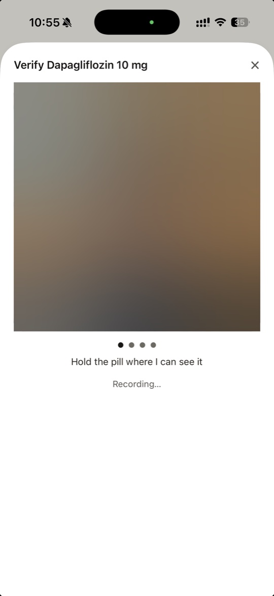 Recording a dose on iPhone: the camera view with the prompt to hold the pill where it can be seen, and step markers underneath showing how far through you are.